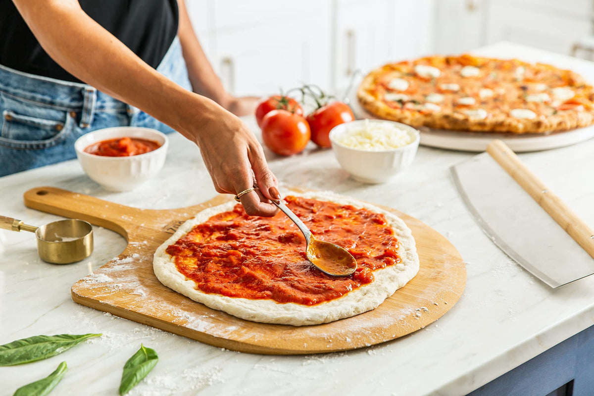 Cuzi Gourmet XL 4-Piece Pizza Stone Set - 15" Thermal Shock Resistant Cordierite Baking Stone, 22" Natural Bamboo Peel & Cutter Rocker - Large Stone for Grill and Oven